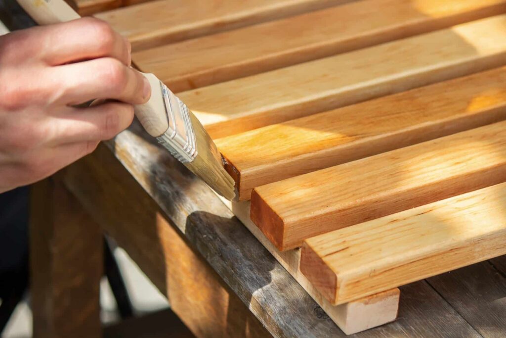 a person painting a wood surface